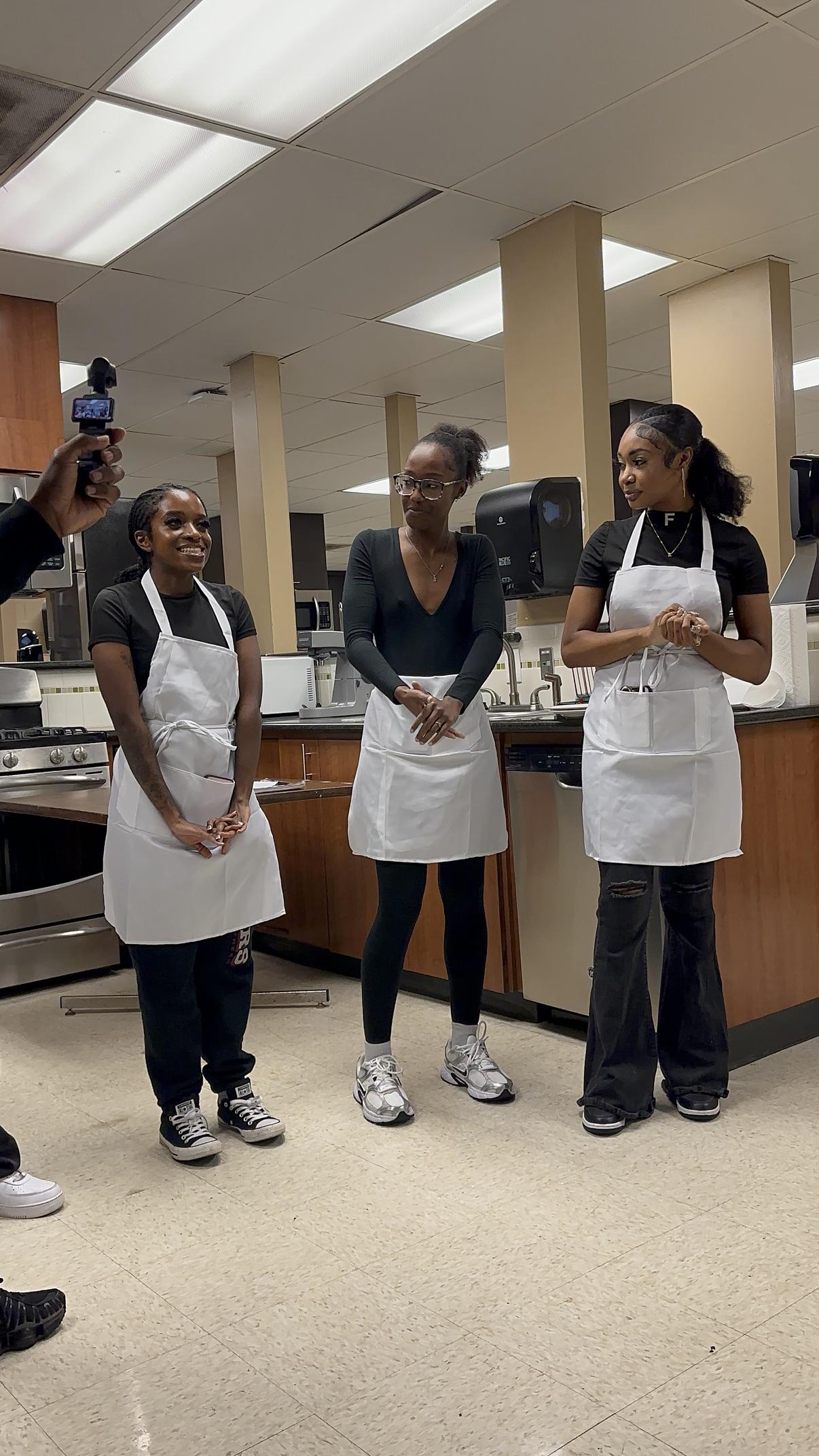 Students in aprons working in a kitchen classroom